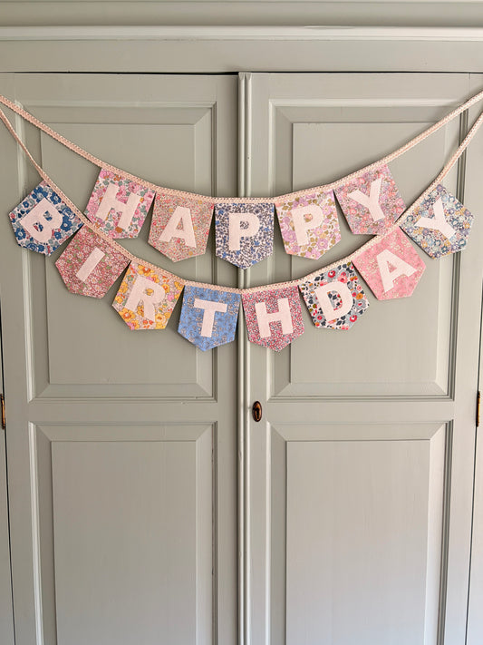 Liberty London Floral Print Bunting with ivory felt happy birthday applique letters hung on wardrobe